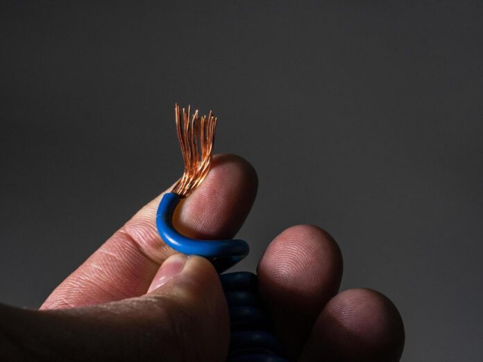 3024020-blue-wire-bare-at-the-end-close-up-na-mao-de-um-homem-gratis-foto